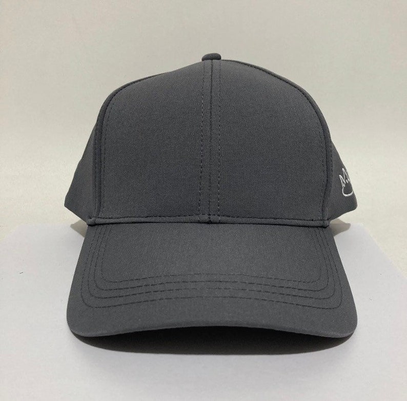 May include: A dark grey baseball cap with a white embroidered logo on the side.