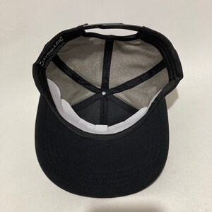 May include: Black baseball cap with a black brim and a black mesh back. The cap has a white label with the text "JAYRAULER" on the inside.