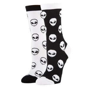 May include: A pair of black and white socks with an alien face pattern. The socks are crew length and have a ribbed cuff.