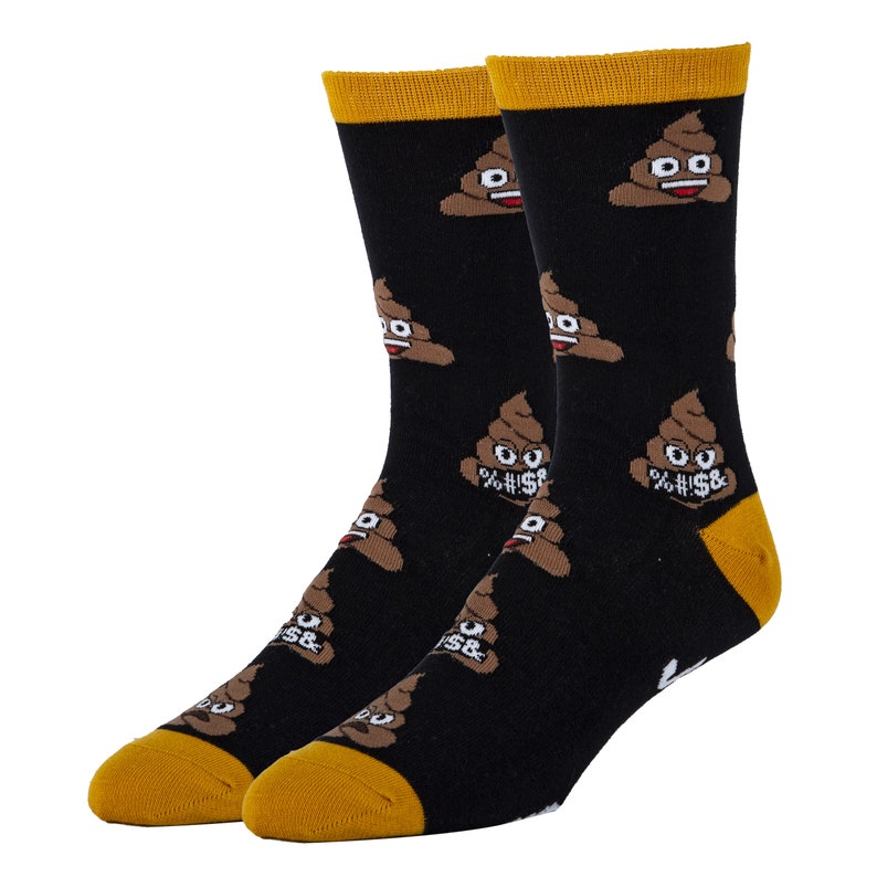 Puede incluir: Un par de calcetines negros con un patr&oacute;n de emoji de caca marr&oacute;n. Los calcetines tienen un pu&ntilde;o amarillo.