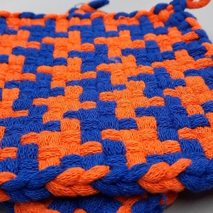 May include: Two blue and orange woven pot holders. The pot holders are square and have a woven pattern.