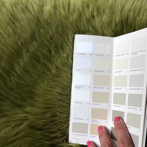 May include: A paint color chart with a variety of white and off-white paint colors. The chart is open to the page showing the colors "All White", "White Tie", "Slipper Satin", "School House White", "Wevet", "New White", "Lime White", "Shadow White", "Wimborne White", "Matchstick", "Off-White", "Shaded White", "Pointing", "String", "Old White", "Drop Cloth", "James White", "Savage Ground", "Stony Ground", and "Corjl".