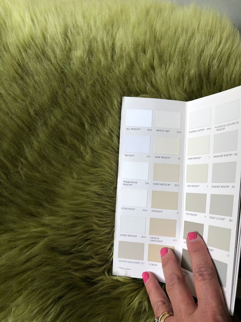 May include: A paint color chart with a variety of white and off-white paint colors. The chart is open to the page showing the colors "All White", "White Tie", "Slipper Satin", "School House White", "Wevet", "New White", "Lime White", "Shadow White", "Wimborne White", "Matchstick", "Off-White", "Shaded White", "Pointing", "String", "Old White", "Drop Cloth", "James White", "Savage Ground", "Stony Ground", and "Corjl".