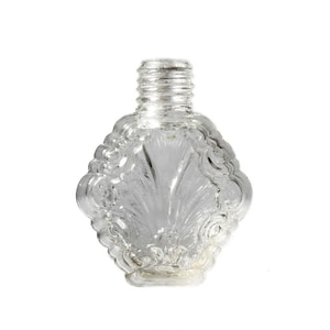 Peut inclure: Une bouteille en verre transparent avec un motif décoratif en forme de coquille. La bouteille a une petite ouverture en haut et un motif texturé et orné.