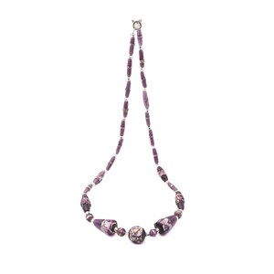 May include: A purple beaded necklace with a silver clasp. The necklace features a variety of purple beads, including cylindrical and round shapes. The beads have a marbled appearance with gold and white accents.