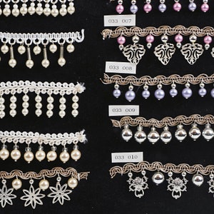 Set di 10 pezzi vintage cechi, pendenti con perline, nastri, pizzi, frange, lampade, abiti, cappelli, bambole, campionario