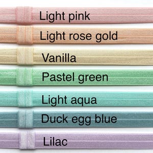 Puede incluir: Siete gomas el&aacute;sticas para el pelo de diferentes colores, de izquierda a derecha: rosa claro, oro rosa claro, vainilla, verde pastel, azul claro, azul huevo de pato y lila.