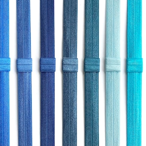 May include: Eight hair ties in various shades of blue, teal, and light blue. The hair ties are made of a stretchy, textured material.