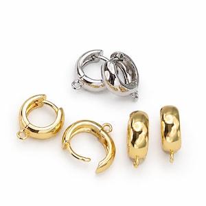 May include: A collection of small, circular hoop components for jewelry making, featuring a hinged closure and a small attached loop. The set includes two silver-toned hoops and four gold-toned hoops, all with a smooth, polished metallic finish.