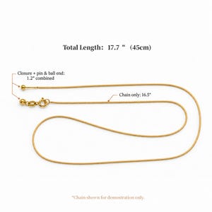 May include: A gold-toned snake chain necklace featuring a spring ring clasp and a pin and ball end. Text indicates a total length of 17.7 inches, a chain length of 16.5 inches, and a combined closure, pin, and ball end length of 1.2 inches.