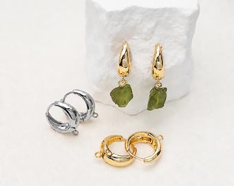 May include: A pair of gold-toned hoop earrings featuring dangling raw green stone pendants, alongside a pair of silver-toned hoop earring findings and a pair of gold-toned hoop earring findings, each with a small loop for attaching charms.