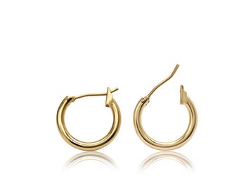 May include: A pair of small, polished gold hoop earrings with a circular design. Each earring features a thin, smooth metal band and a hinged post closure mechanism that extends upward from the top of the hoop, creating a simple, classic silhouette.