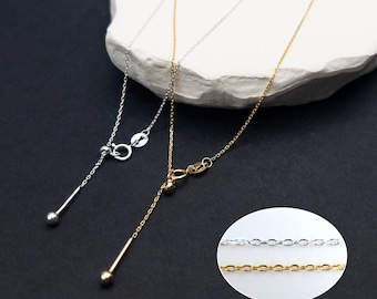 May include: Two adjustable necklaces, one in silver tone and one in gold tone, each featuring a delicate chain, a sliding bead mechanism for length adjustment, and a small dangling metal rod with a spherical tip at the end of the adjustment chain.