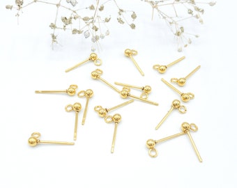 May include: A collection of gold-colored metal earring posts, each featuring a small spherical bead and a tiny circular loop at the top for attaching charms or dangles. These jewelry components have a smooth, polished finish and straight pins.