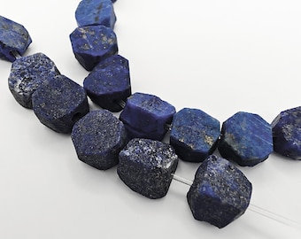 Könnte beinhalten: Ein Strang aus rohen, tiefblauen Lapislazuli-Perlen mit unregelmäßigen, facettierten Formen. Jeder Stein weist natürliche Variationen in Textur und Farbe auf, einschließlich goldener Pyrit-Einschlüsse, aufgereiht auf einem klaren, dünnen Faden.