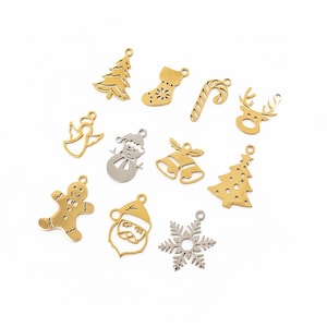 Puede incluir: Una colección de once dijes navideños de metal en tonos dorados y plateados. El surtido incluye formas de árbol de Navidad, calcetín, bastón de caramelo, reno, ángel, muñeco de nieve, campanas, hombre de jengibre, Santa Claus y un copo de nieve.