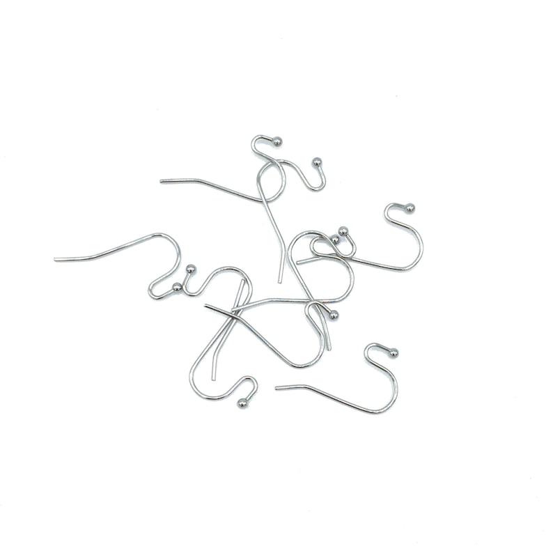 May include: A collection of silver-toned metal earring hooks, each featuring a curved wire design with a small decorative ball at the end. These jewelry findings are shaped for insertion into the earlobe and are used for crafting hanging earrings.