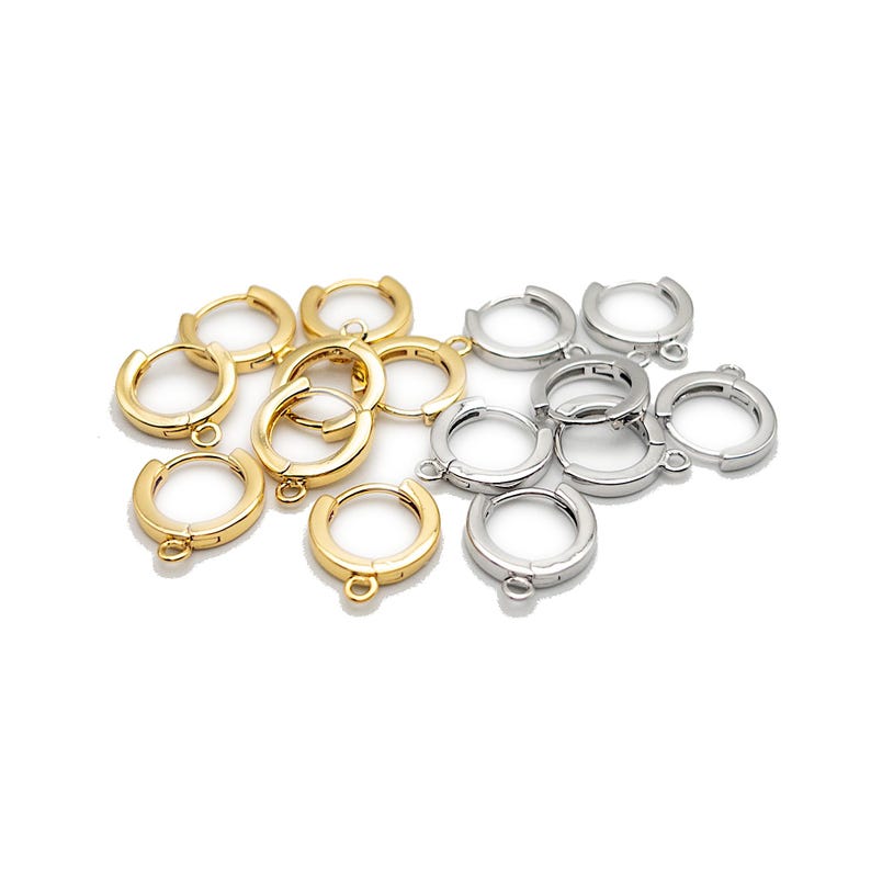 May include: A collection of small, circular hoop earring findings with hinged closures and attached loops for jewelry making. The set includes several pieces finished in a polished gold tone and several pieces finished in a polished silver tone.
