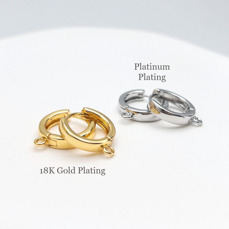Op de afbeelding: Twee kleine ronde oorringonderdelen met bevestigde lusjes voor het maken van sieraden. E&eacute;n paar is voorzien van 18K goudplating en het andere paar van platina plating. De tekst 18K Gold Plating en Platinum Plating is zichtbaar.