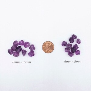 Peut inclure: Deux groupes de pierres d'am&eacute;thyste violettes brutes dispos&eacute;es de chaque c&ocirc;t&eacute; d'une pi&egrave;ce de cuivre. Le groupe de gauche est &eacute;tiquet&eacute; 8mm - 10mm et le groupe de droite 6mm - 8mm. Les pierres ont des formes irr&eacute;guli&egrave;res et des nuances de violet.