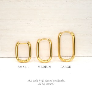 May include: Three gold-plated hoop earrings in different sizes: small, medium, and large. The earrings are oval-shaped and have a smooth finish. 18K gold PVD plated available. STER-0023G