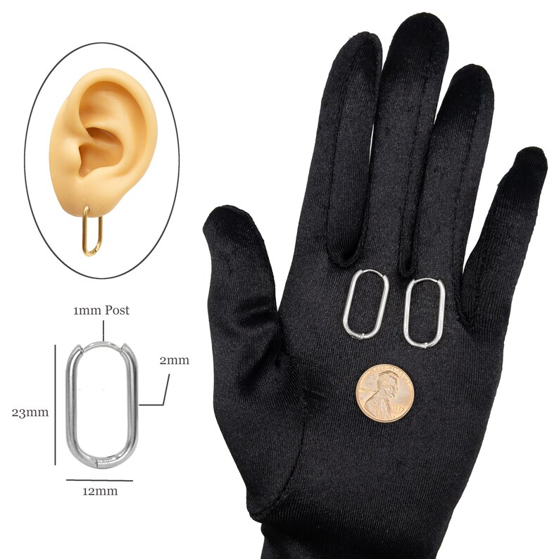 May include: Silver oval hoop earrings with a 1 mm post. The earrings are 23 mm long and 12 mm wide. The earrings are shown on a black glove.