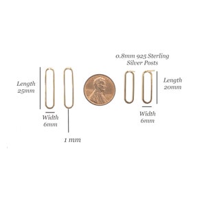 Puede incluir: Dos pares de pendientes ovalados dorados con postes de plata de ley 925 de 0,8 mm. Un par mide 25 mm de largo y 6 mm de ancho, el otro 20 mm de largo y 6 mm de ancho. Se muestra una moneda de cobre para comparar, el grosor del alambre es de 1 mm.