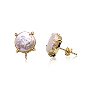 May include: A pair of gold stud earrings with a round, white pearl in each setting. The pearl has a slightly iridescent sheen.