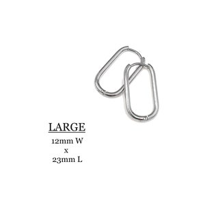 May include: A pair of large silver hoop earrings. The earrings are oval shaped and measure 12mm wide by 23mm long. LARGE 12mm W x 23mm L