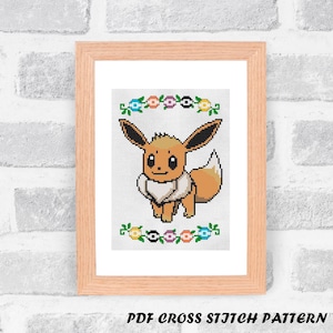 May include: Cross stitch pattern featuring a brown and white Eevee Pokemon with a flower border. The pattern is in a wooden frame and is labeled "PDF CROSS STITCH PATTERN".