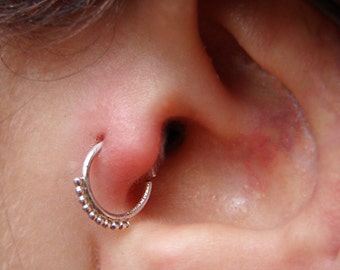 Könnte beinhalten: Nahaufnahme einer Nase mit einem kleinen silbernen Nasenring. Der Ring hat ein Perlenmuster.
