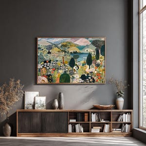 Puede incluir: Un cuadro de paisaje rectangular en un marco de madera fina que presenta una escena estilizada de colinas onduladas, un lago azul central y densos grupos de flores y &aacute;rboles coloridos en tonos verdes, naranjas, amarillos y blancos.
