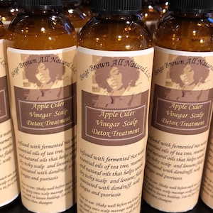 Puede incluir: Tres botellas de vidrio marr&oacute;n con tapas de pulverizador negras y etiquetas que dicen "Beige Brown All Natural LLC" y "Apple Cider Vinegar Scalp Detox Treatment". Las etiquetas tambi&eacute;n incluyen un dibujo de una mujer con cabello rizado.