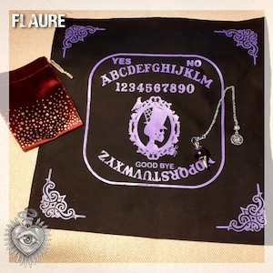 May include: A black felt Ouija board with purple lettering and a purple and silver pendulum. The board features the letters A-Z, numbers 1-9, 0, YES, NO, and GOOD BYE. The board is surrounded by a decorative border.