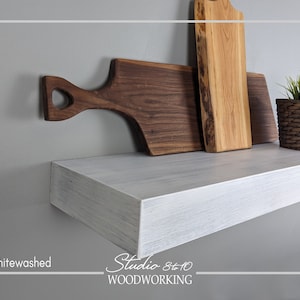 May include: Whitewashed wooden shelf with three wooden cutting boards, one with a heart-shaped handle, and a small potted plant. The shelf is labeled "Studio 8+10 WOODWORKING".