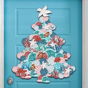 May include: A Christmas tree-shaped decoration made of various shades of blue, pink, and red. The decoration is made of seashells, coral, and starfish. It is a unique and festive way to decorate for the holidays.