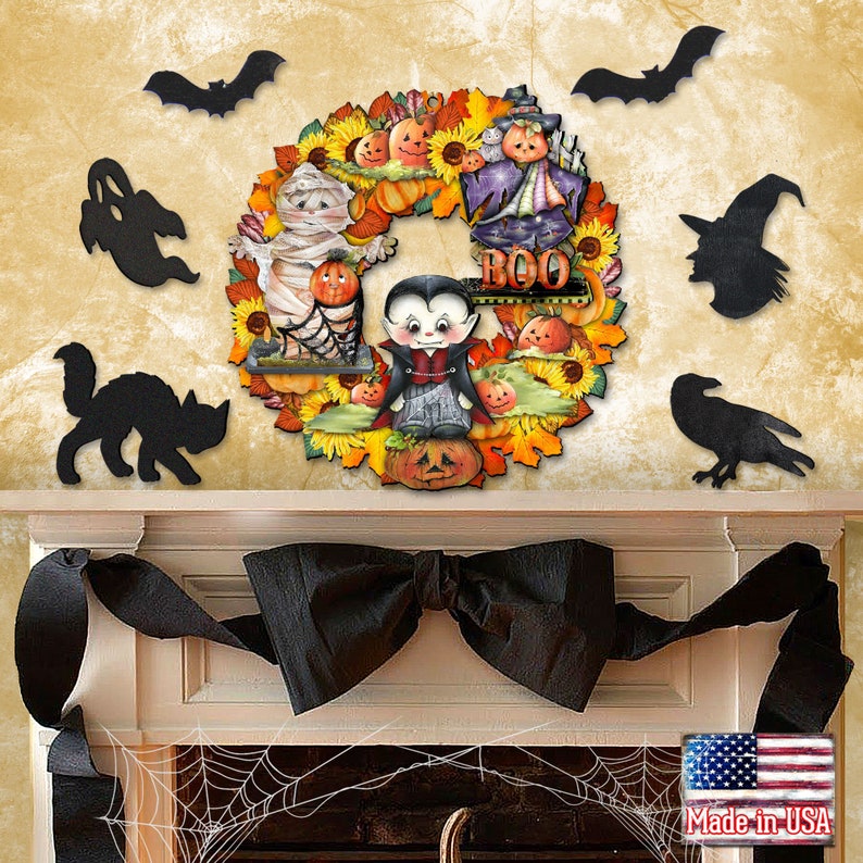 Peut inclure: Une couronne d'Halloween avec un chat noir, un fant&ocirc;me, un corbeau, des chauves-souris et une sorci&egrave;re. La couronne est d&eacute;cor&eacute;e de citrouilles, de tournesols et de feuilles. Le texte "BOO" est sur la couronne.