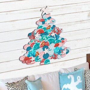 May include: A colorful Christmas tree decoration made of seashells, coral, and starfish. The tree is decorated with pearls and has a pink and blue color scheme.