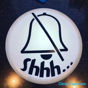May include: White round sign with a black bell crossed out and the text "Shhh..." in black.