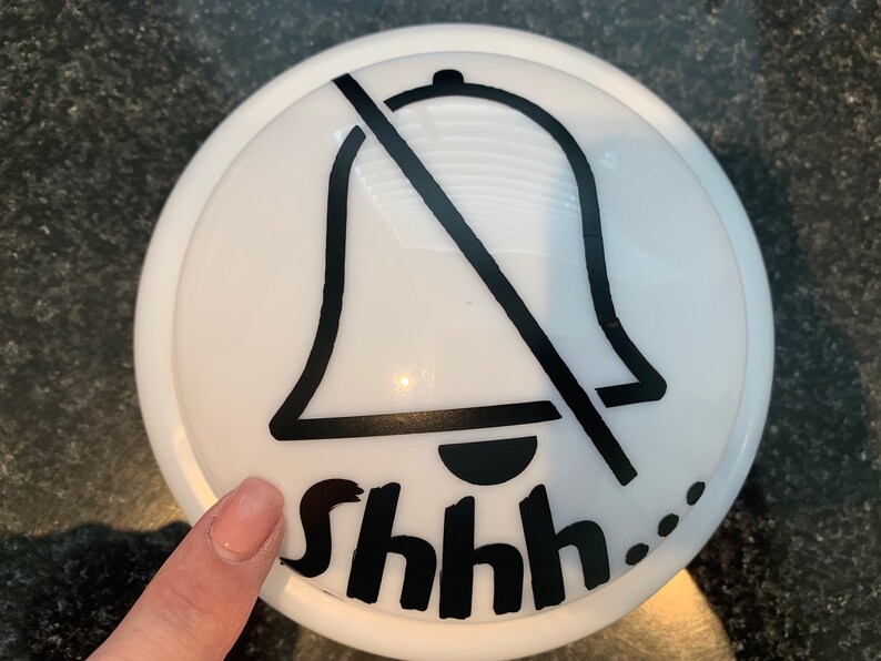 May include: White round button with a black bell icon crossed out and the text "shhh..." printed below.