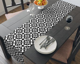 Caminho de mesa com estampa geométrica floral em preto e branco, motivo moderno de azulejo.