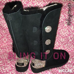 May include: Black suede boots with a fur cuff and rhinestone buttons. The boots have a black sole and are decorated with rhinestones. The text "bling it on" is written on the boots.