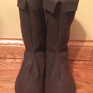 May include: A pair of brown felt boots with a folded cuff at the top.