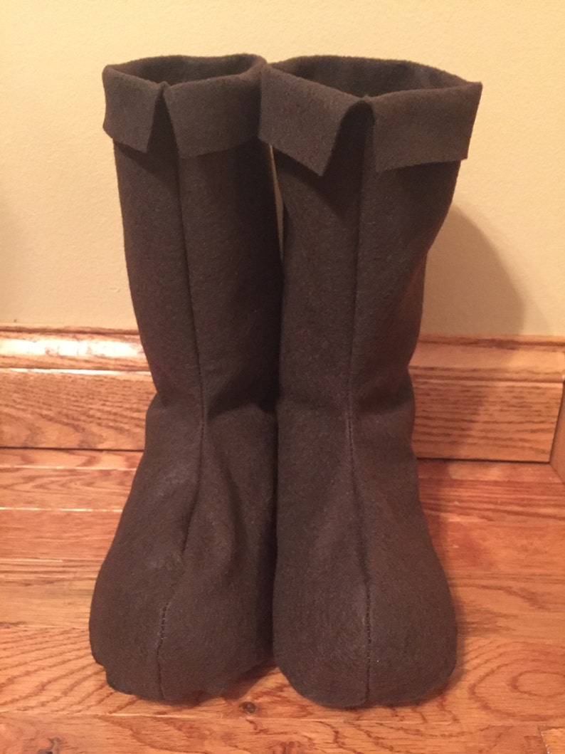 May include: A pair of brown felt boots with a folded cuff at the top.