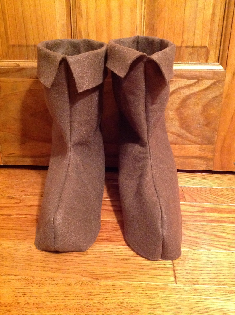 May include: A pair of brown felt boots with a folded-over top.