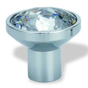 Peut inclure: Un bouton de porte en chrome avec un dessus en cristal transparent.