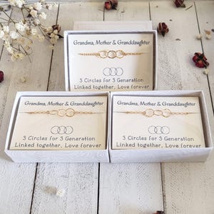 May include: Three gold-colored bracelets, each with three linked circles, are displayed in white boxes. The boxes have text that reads "Grandma, Mother & Granddaughter" and "3 Circles for 3 Generation Linked together, Love forever."