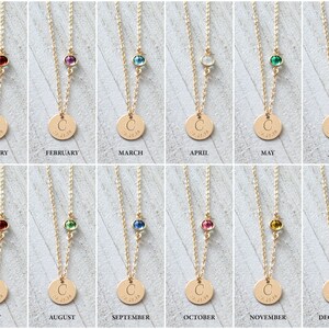 May include: Twelve gold necklaces with a small round charm and a single gemstone. Each necklace features a different colored gemstone representing a month of the year. The charms are engraved with the letter "C" and the date "02.27.18".