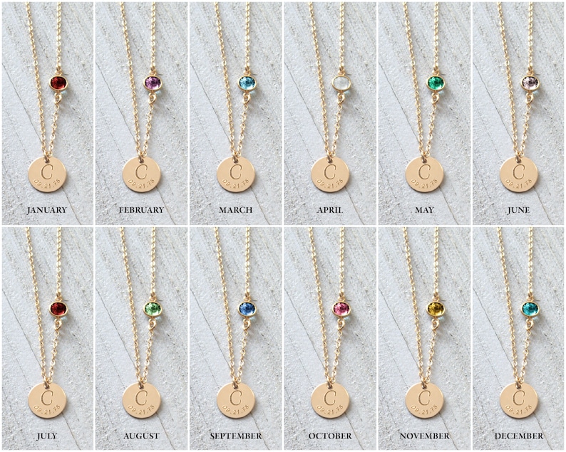May include: Twelve gold necklaces with a small round charm and a single gemstone. Each necklace features a different colored gemstone representing a month of the year. The charms are engraved with the letter "C" and the date "02.27.18".