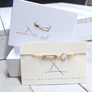 May include: A gold chain bracelet with a small, clear gemstone and a gold charm that says "UNICORN". The bracelet is displayed on a white card with the text "etsy.com/shop/angelicspark".